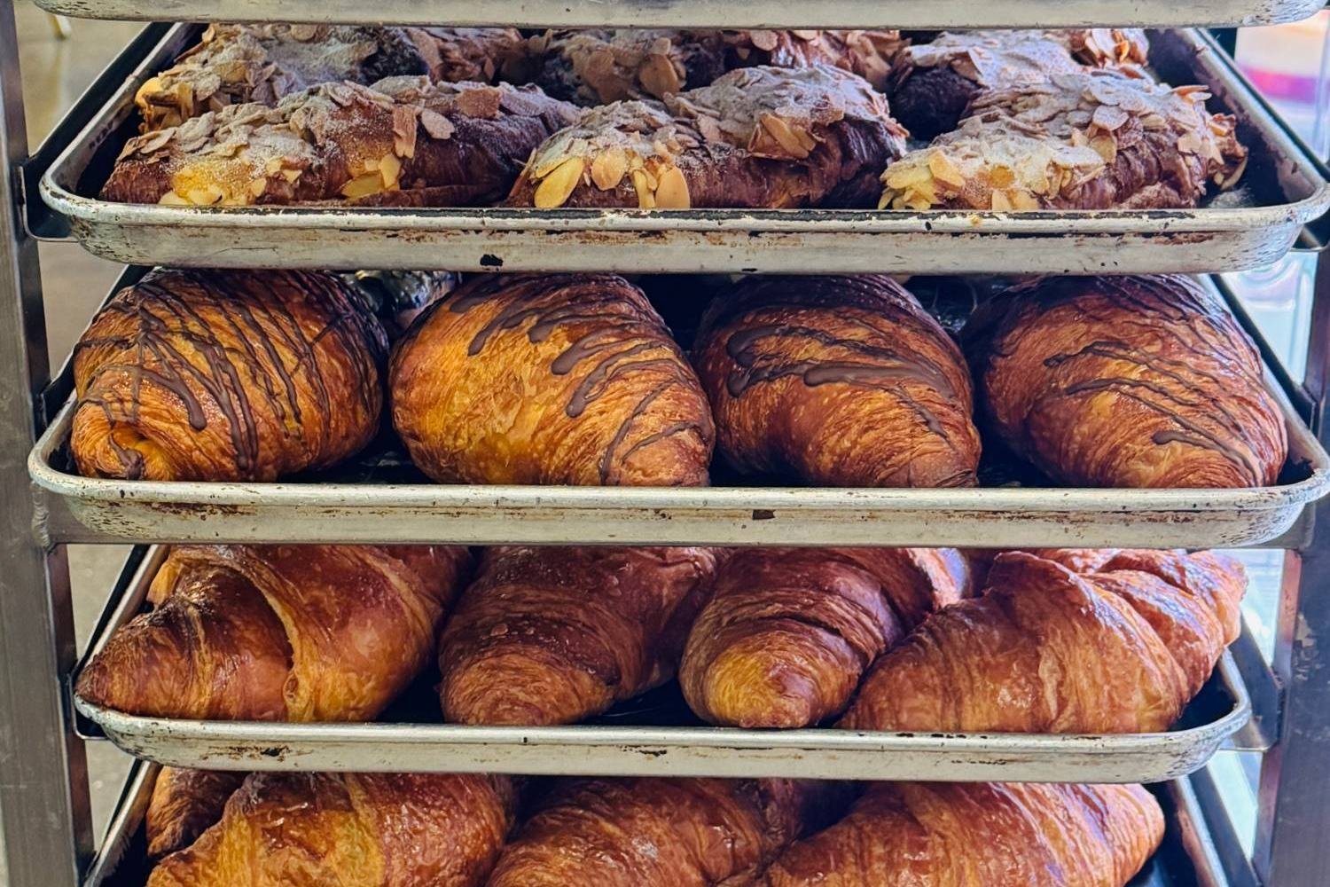 Racks of almond and chocolate croissants fresh from the oven