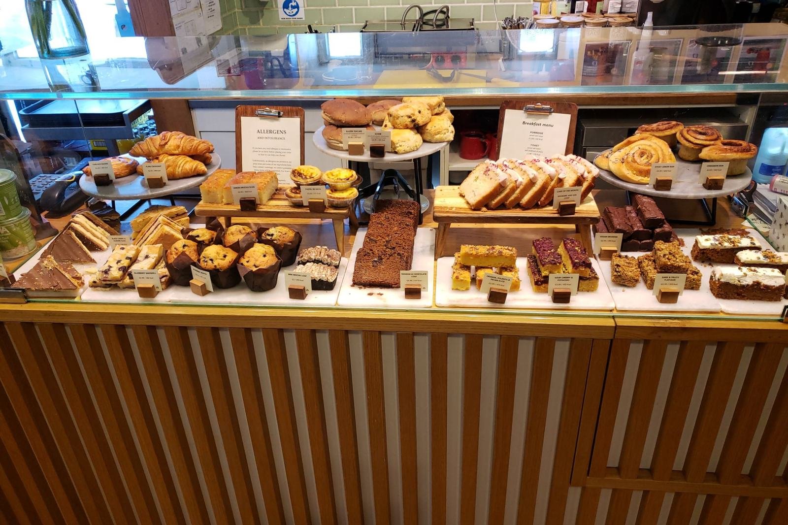 A glass case full of muffins, cakes, brownies and pastries
